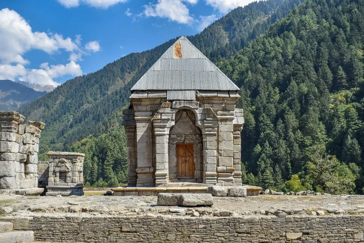 An ancient stone temple among forested mountains at Naranag